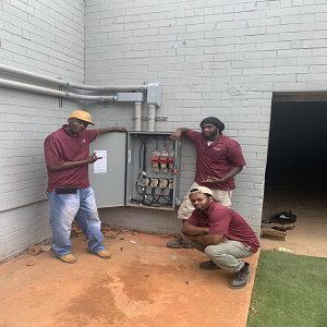 Three men working on a residential electrical system.