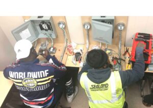 A group of people working on electrical equipment.