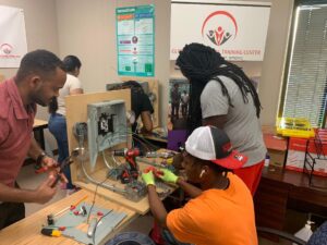 A group of people working on some electrical equipment.